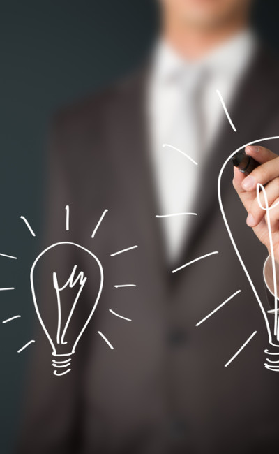 Business man drawing idea lightbulbs on screen.